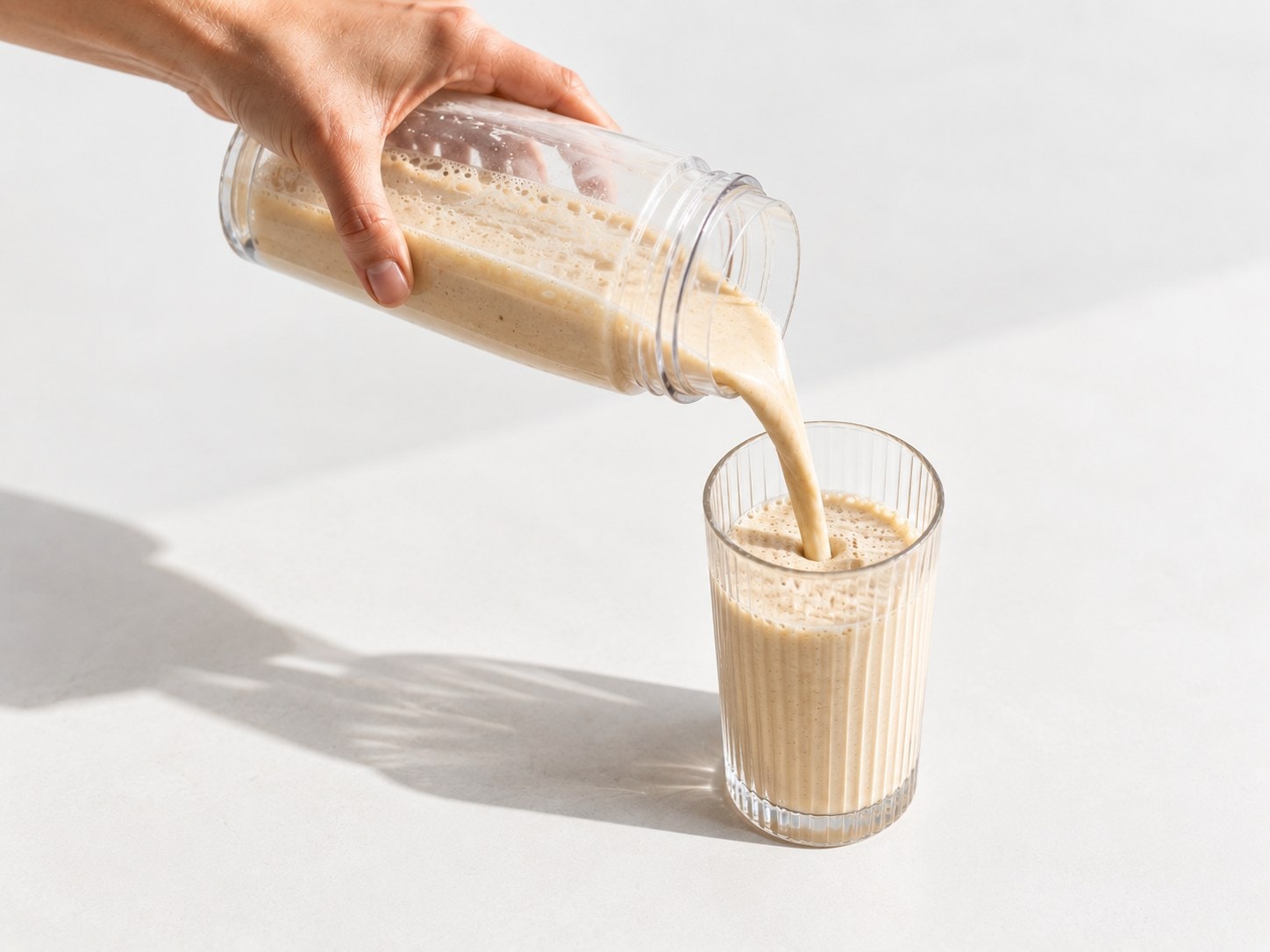 Nalievanie pripraveného proteínového nápoja Powerlogy Whey Protein Coconut & Almond do pohára