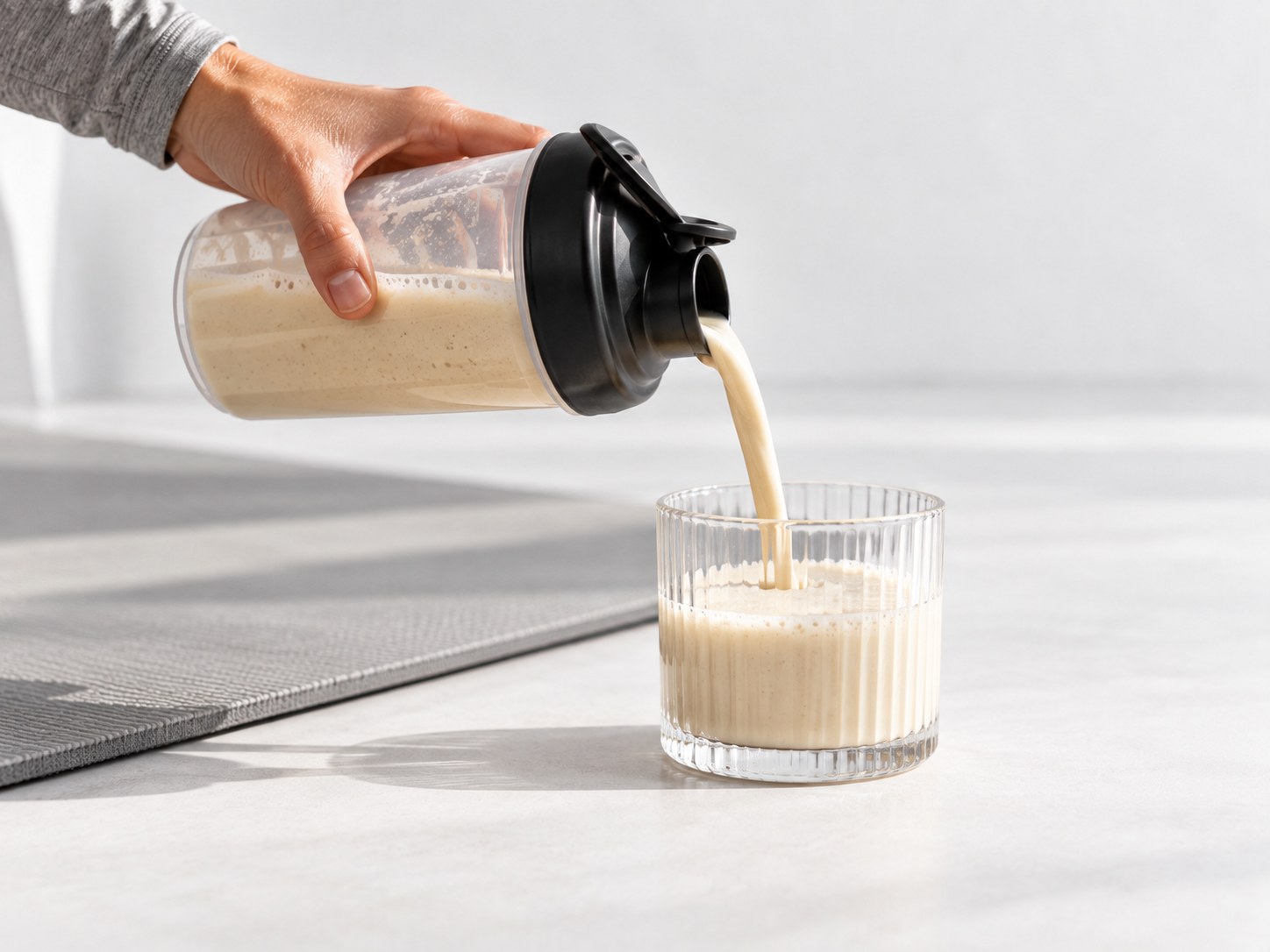 Nalévání nápoje Powerlogy Upgraded Recovery Protein Coconut & Almond do sklenice po tréninku