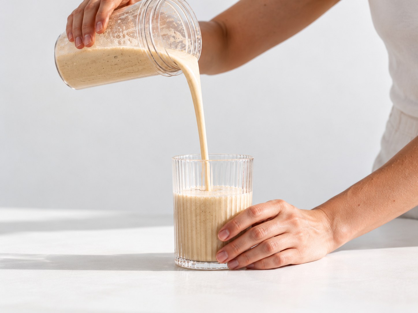 Nalévání připraveného nápoje Powerlogy Organic Vegan Protein s příchutí skořice a vanilka do sklenice
