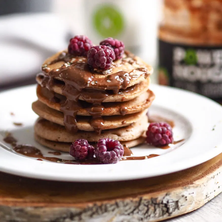 Stapel goldbrauner Pancakes mit Nougat-Creme und frischem Obst